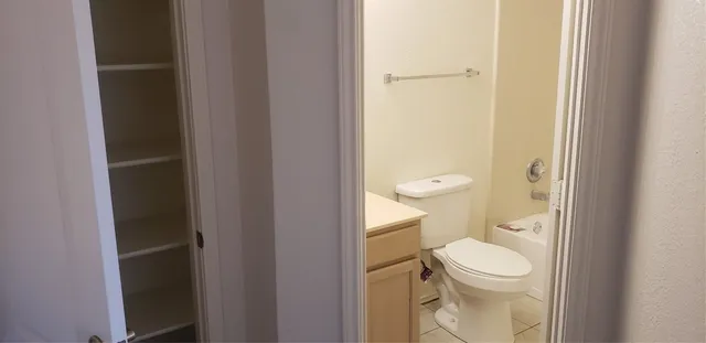 a bathroom with a granite countertop toilet and a sink