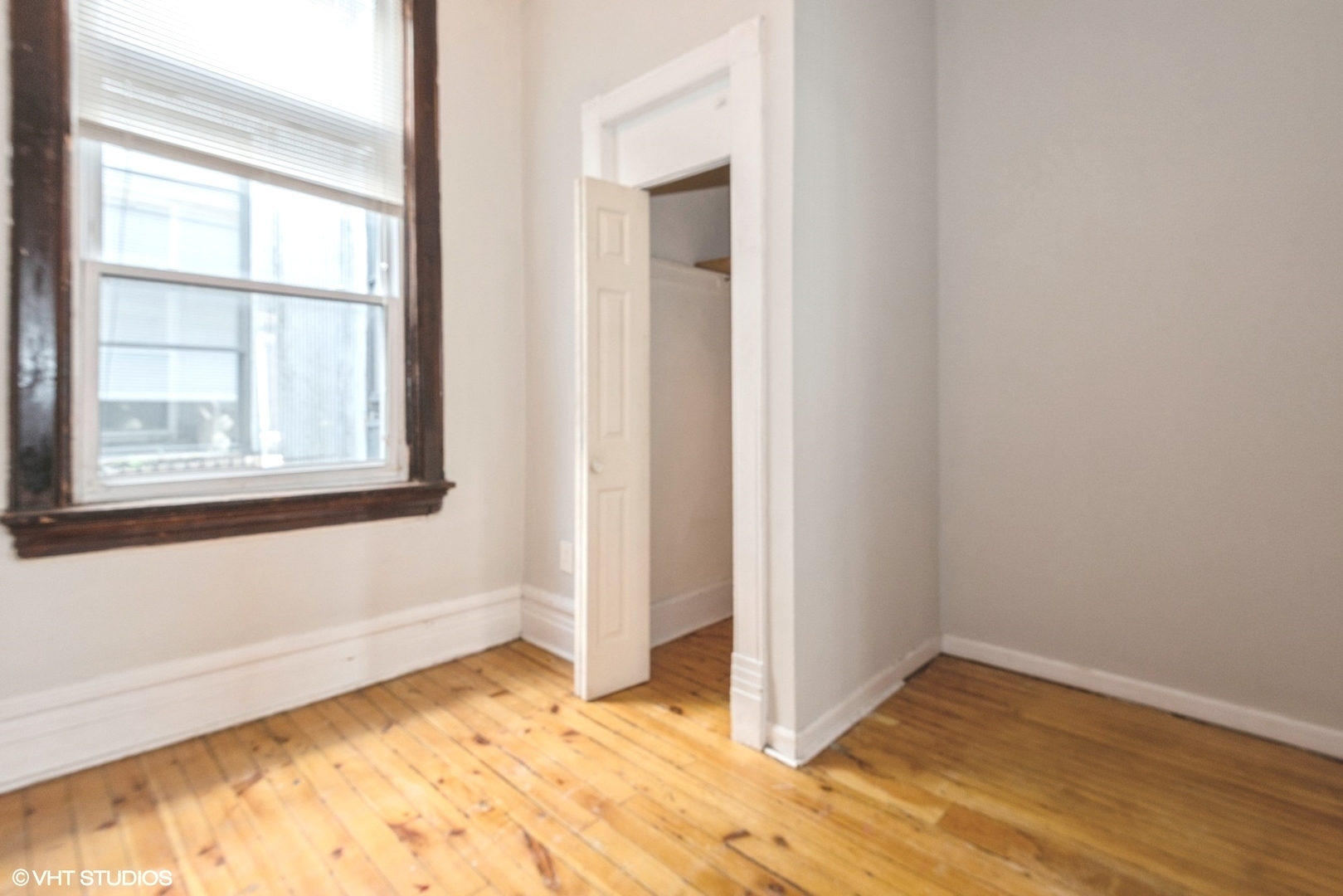 2150 North Halsted Street, Unit 3F Chicago, IL 60614 - Photo 16 of 16 a view of an empty room with wooden floor and a window