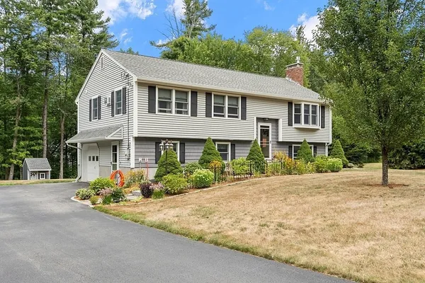 a front view of a house with a yard and potted plants