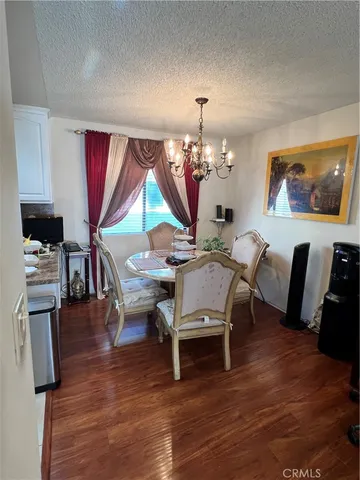 a dining room with furniture a chandelier and wooden floor