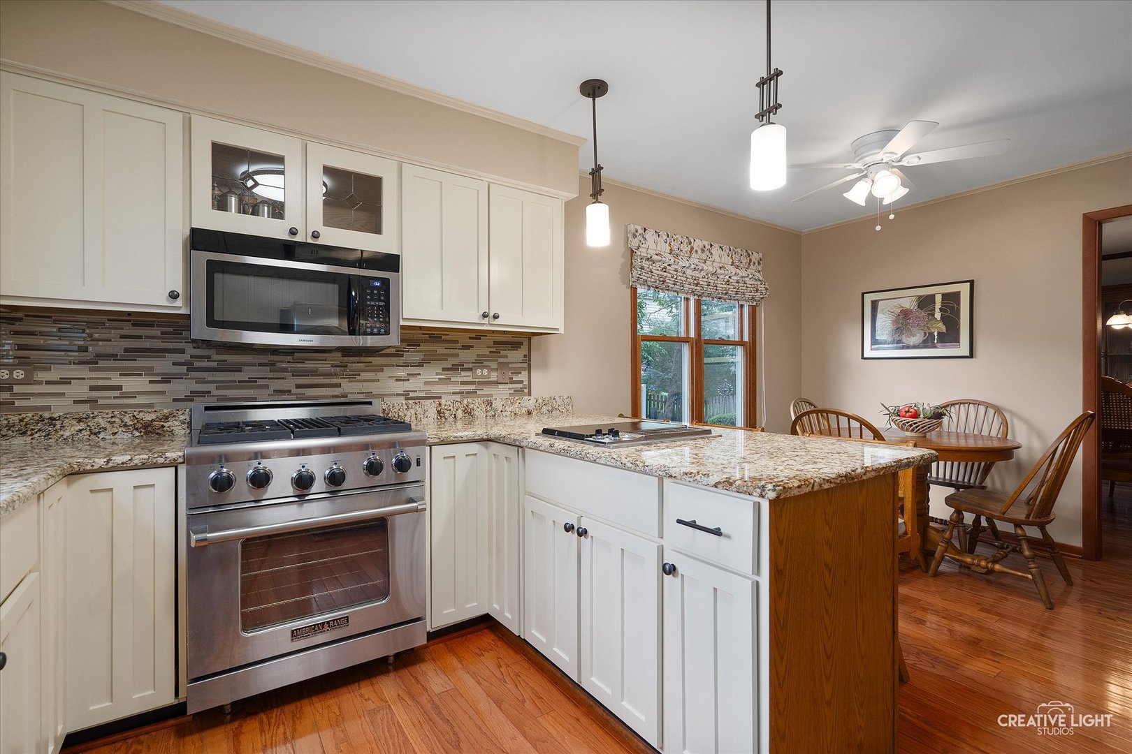 567 Roxbury Drive Naperville, IL 60565 - Photo 15 of 36 a kitchen with a stove a sink a microwave a dining table and chairs
