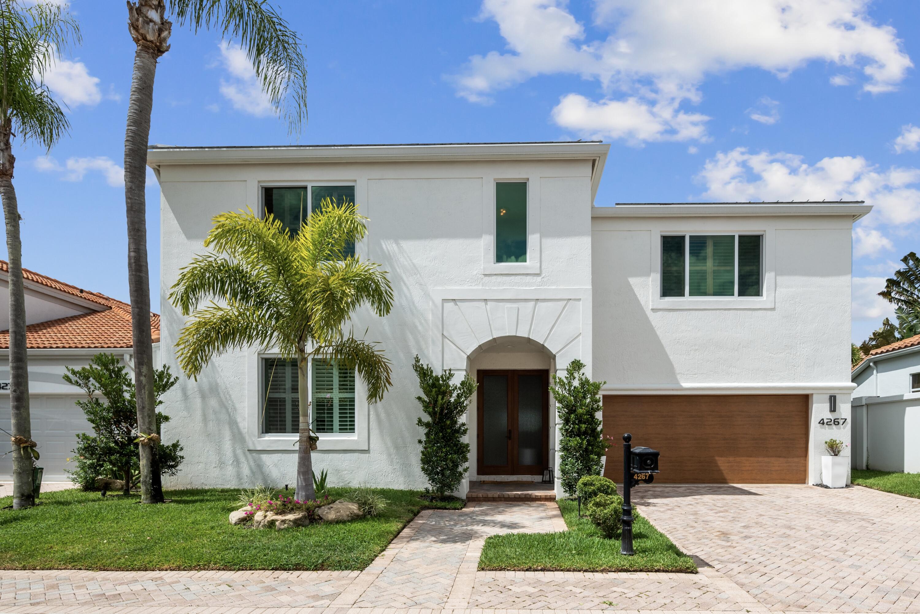 4267 Northwest 65th Place Boca Raton, FL 33496 - Photo 1 of 80 a front view of a house with garden
