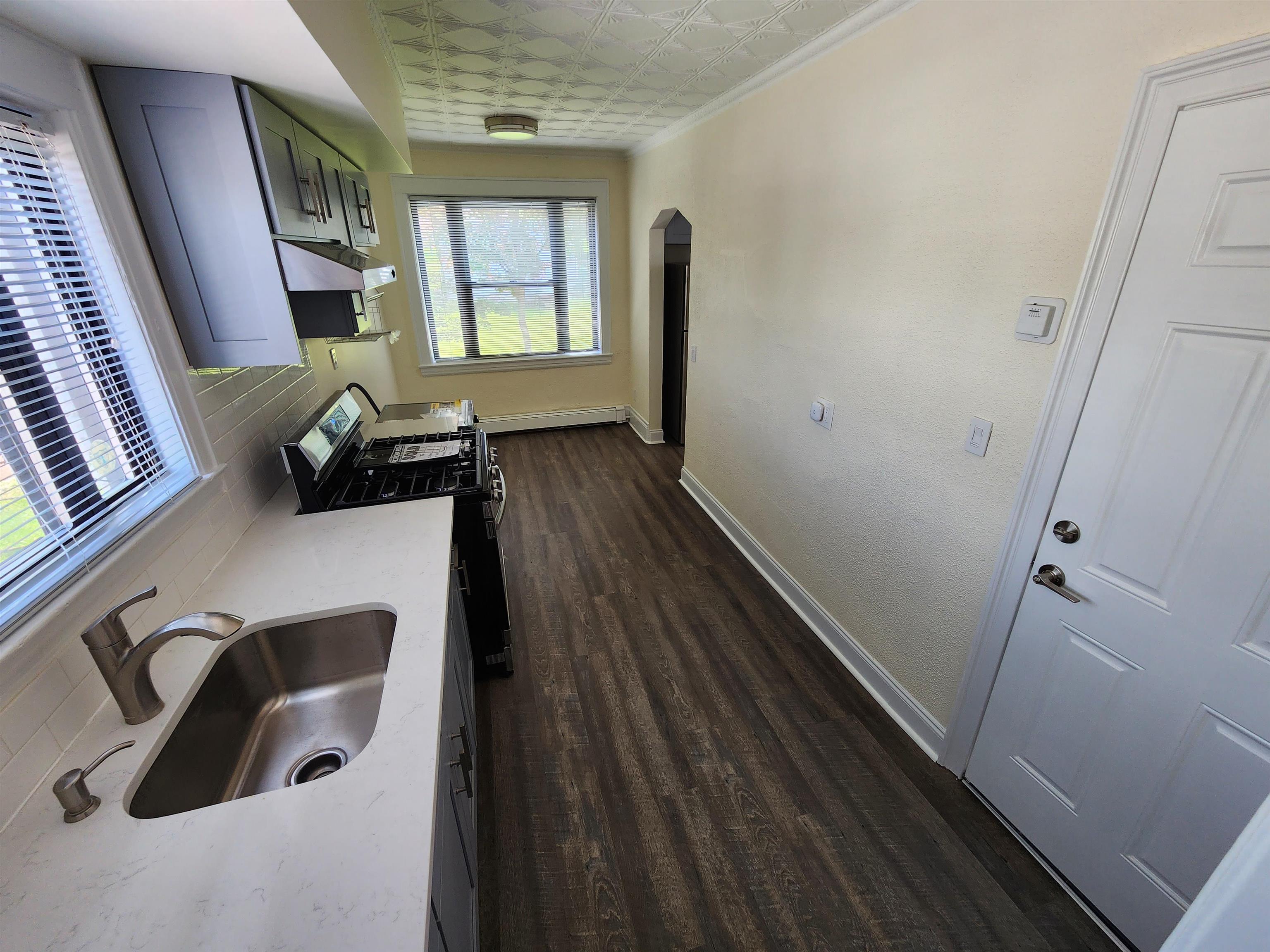 a view of entryway and hall with wooden floor