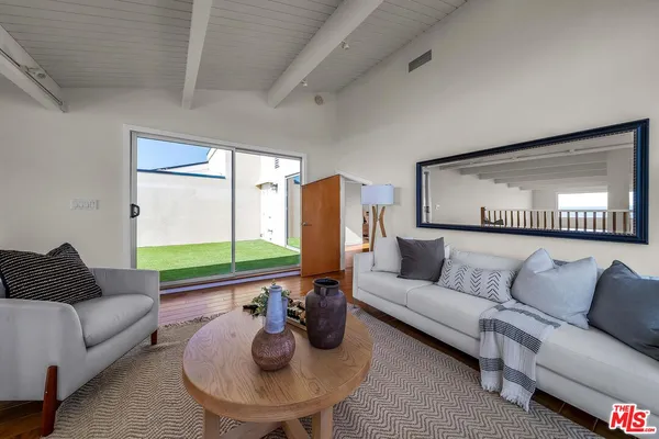 a living room with furniture and a floor to ceiling window