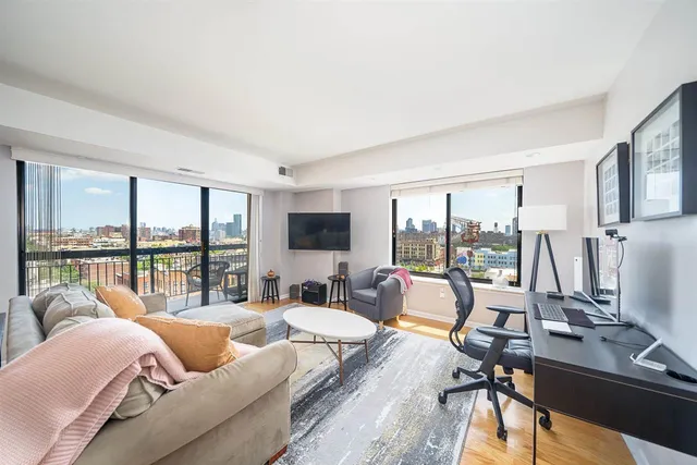 a living room with furniture large windows and a flat screen tv