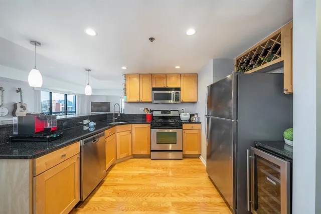a kitchen with stainless steel appliances granite countertop a refrigerator and a sink
