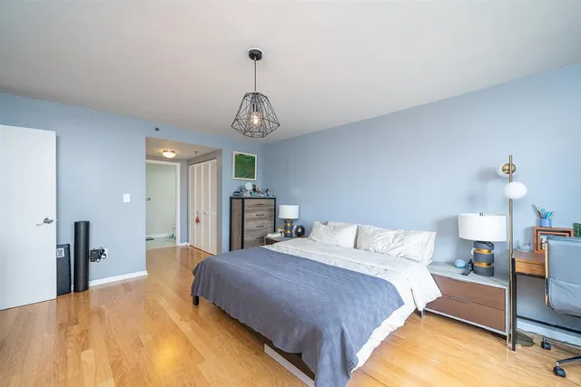a spacious bedroom with a bed and a chandelier