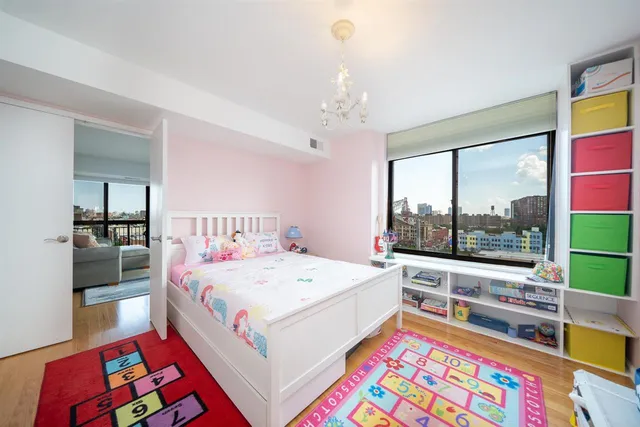 a room with a bed a couch and a flat tv screen on the dresser