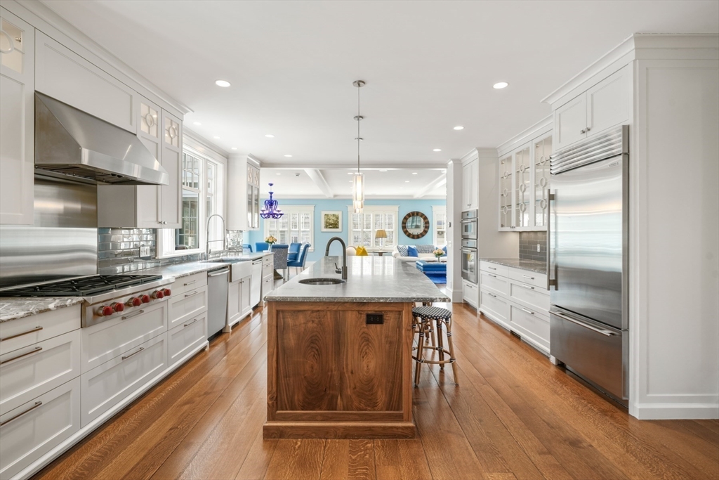 21 Cushing Road Wellesley, MA 02481 - Photo 6 of 31 a kitchen with stainless steel appliances granite countertop a refrigerator a sink dishwasher a stove and white countertops with wooden floor