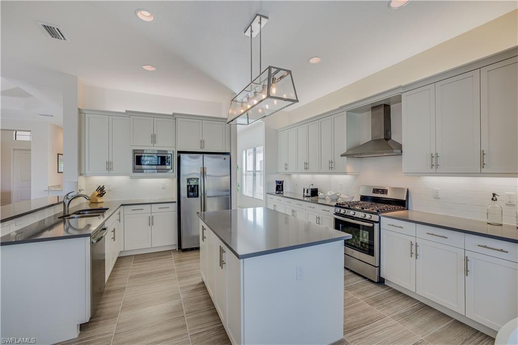 4549 Azalea Drive Naples, FL 34119 - Photo 15 of 25 a kitchen with stainless steel appliances granite countertop a sink stove and refrigerator