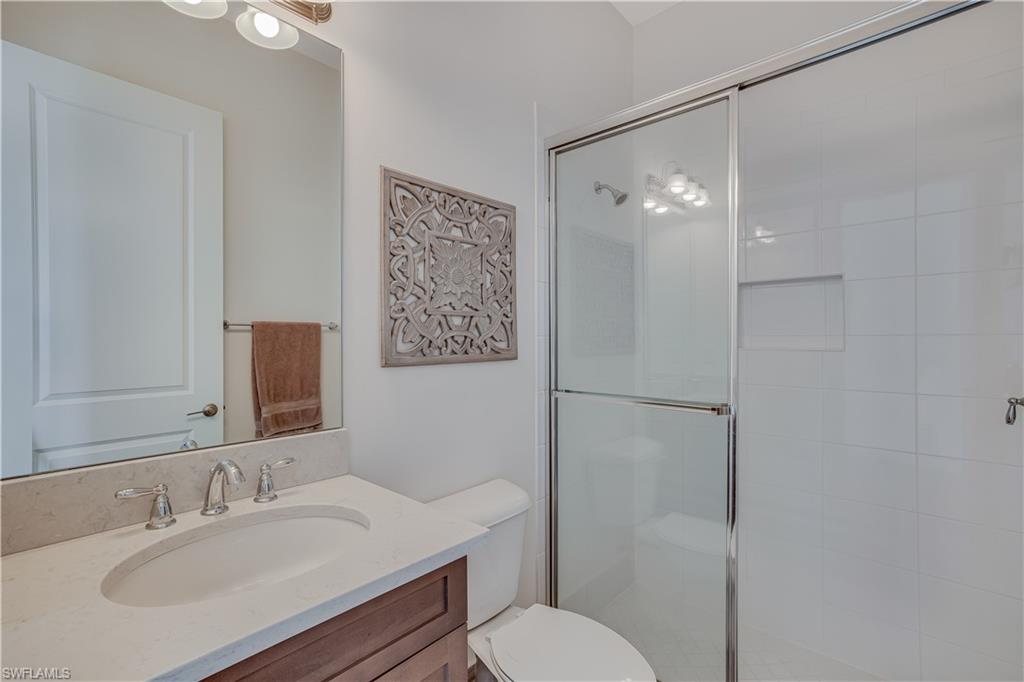 4549 Azalea Drive Naples, FL 34119 - Photo 18 of 25 a bathroom with a sink toilet and shower