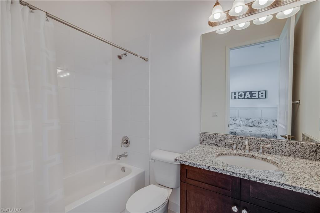 4549 Azalea Drive Naples, FL 34119 - Photo 20 of 25 a bathroom with a granite countertop sink a toilet and bathtub