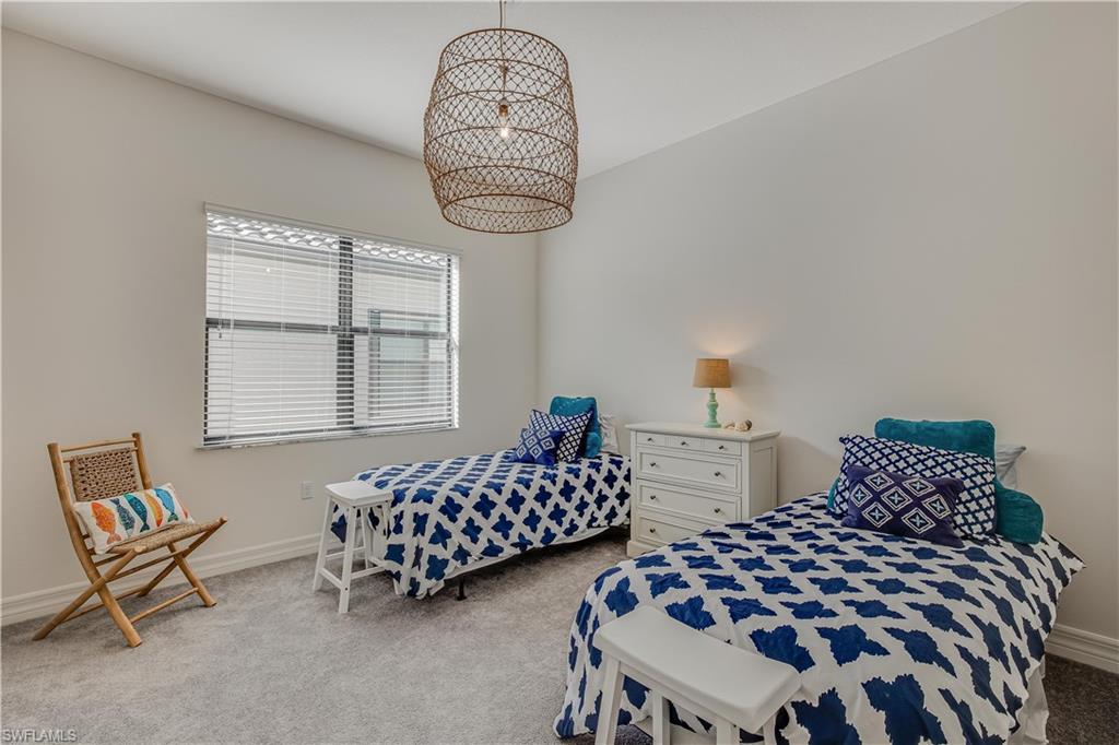 4549 Azalea Drive Naples, FL 34119 - Photo 21 of 25 a bedroom with two beds and a chandelier