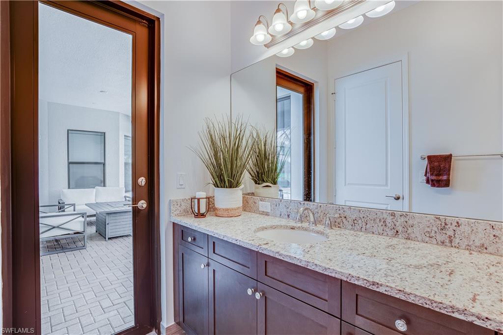 4549 Azalea Drive Naples, FL 34119 - Photo 23 of 25 a en suite bathroom with a granite countertop sink and a mirror