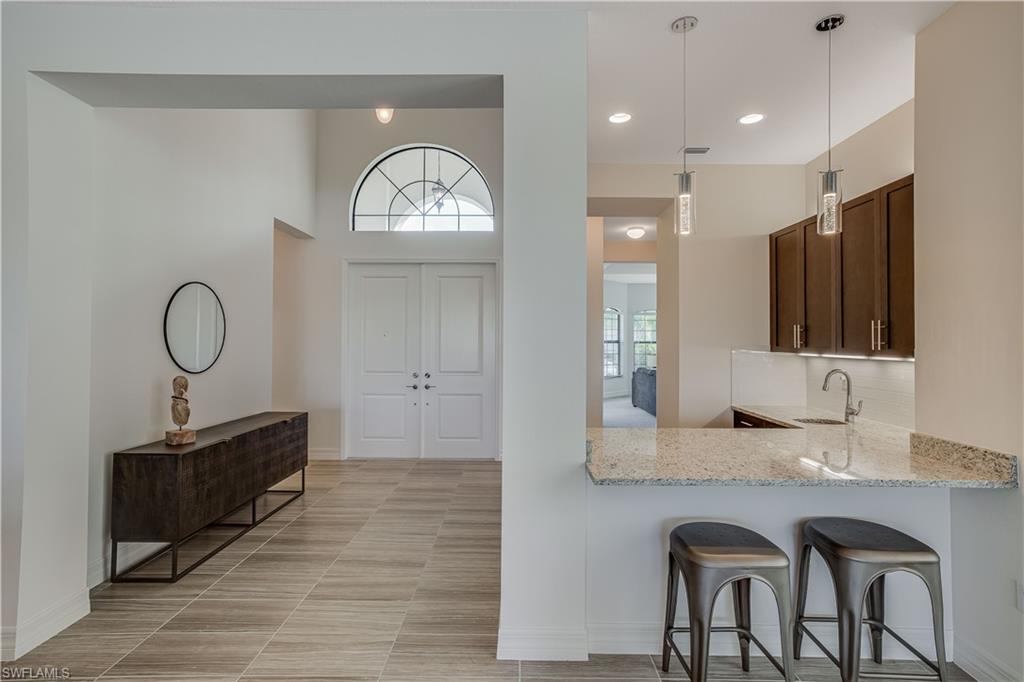 4549 Azalea Drive Naples, FL 34119 - Photo 6 of 25 a spacious bathroom with a granite countertop sink a mirror and a vanity