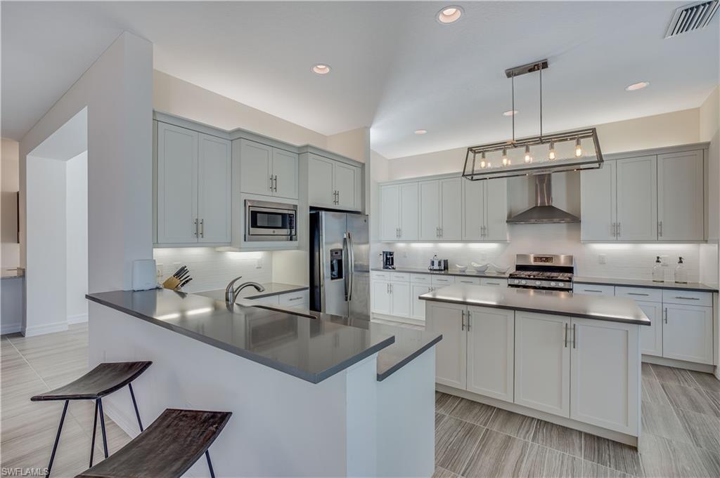 4549 Azalea Drive Naples, FL 34119 - Photo 7 of 25 a kitchen with stainless steel appliances granite countertop a sink stove and refrigerator