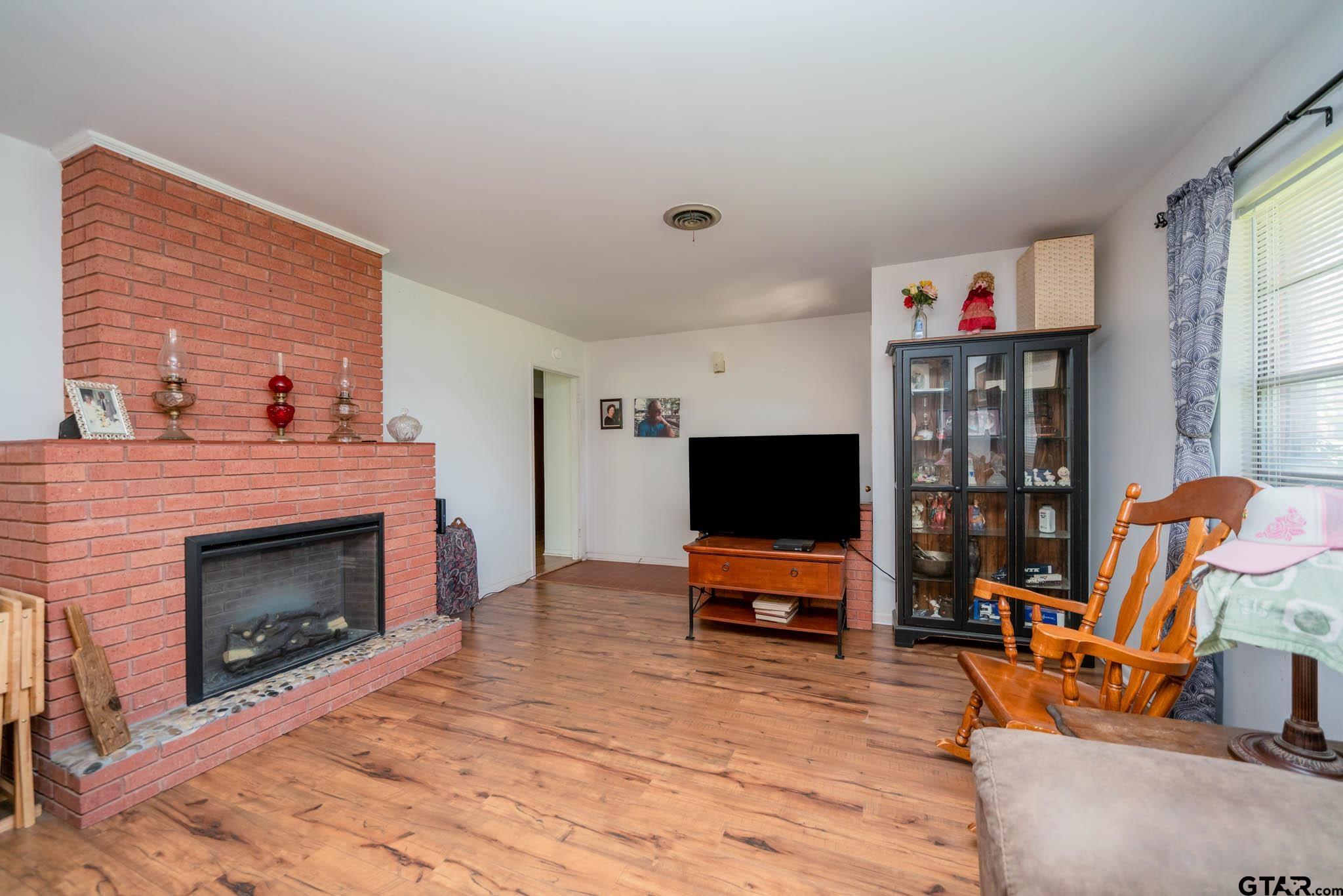 126 Jordan Street Rusk, TX 75785 - Photo 7 of 39 a living room with furniture a fireplace and a flat screen tv