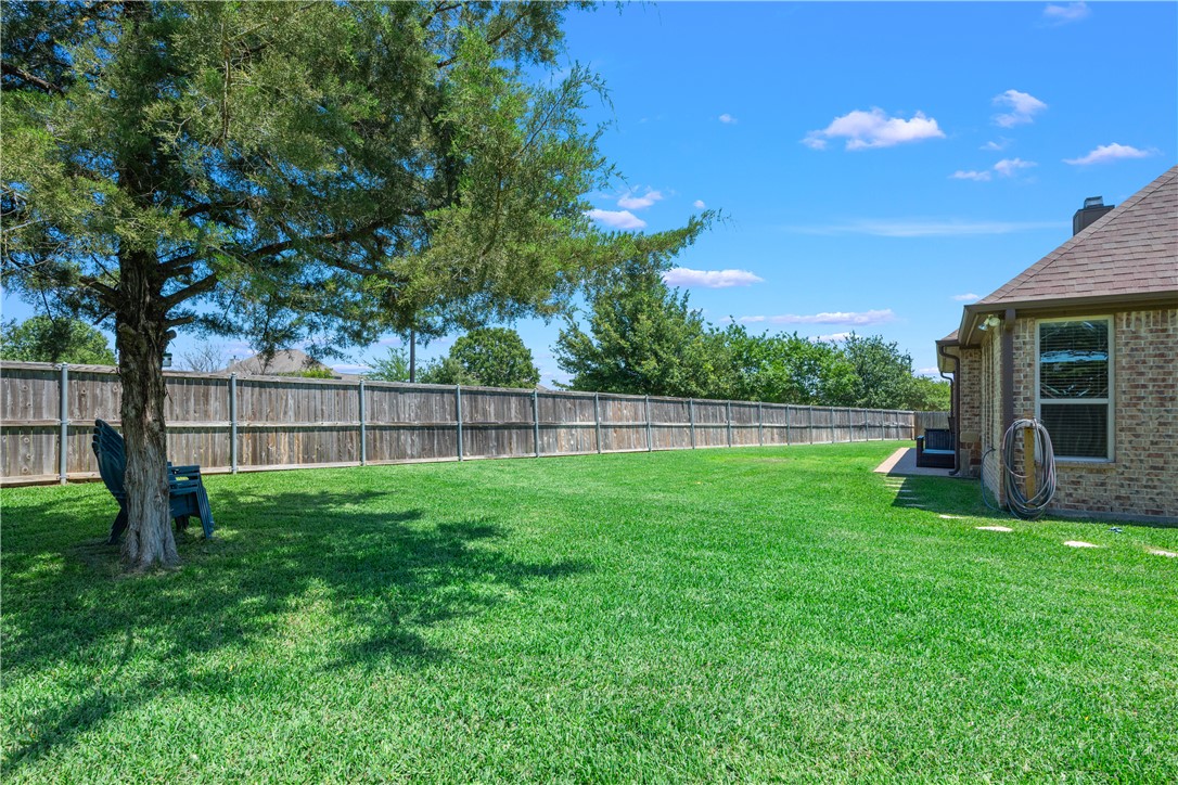 3301 Covington Court Bryan, TX 77808 - Photo 24 of 26 a view of a backyard with grass and a large tree