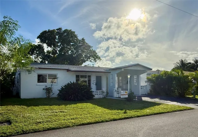 a view of a house with a yard and potted plants