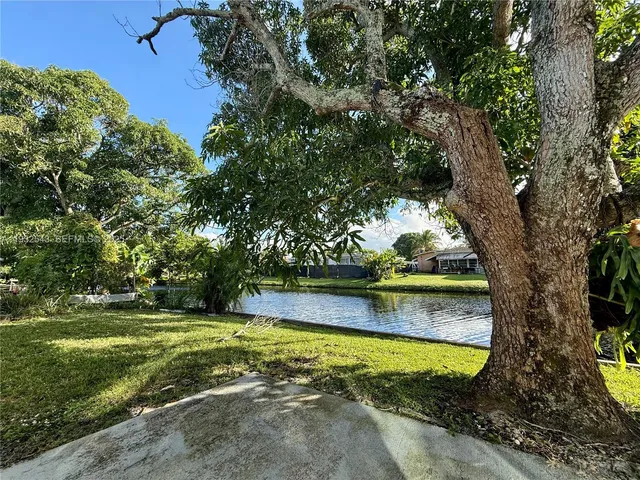 a view of a swimming pool with an outdoor seating and a forest