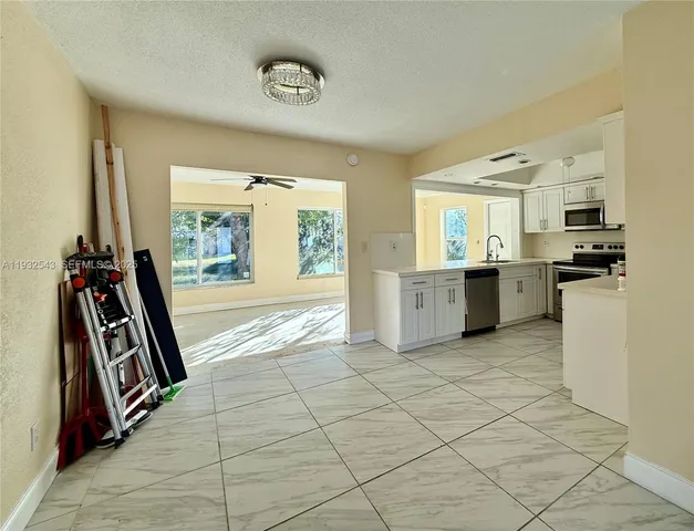 a view of a kitchen with a sink dishwasher and a refrigerator