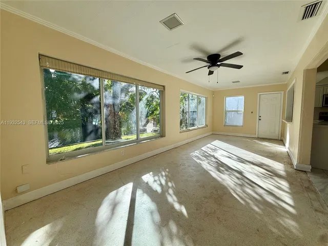 a view of a livingroom with wooden floor and a ceiling fan