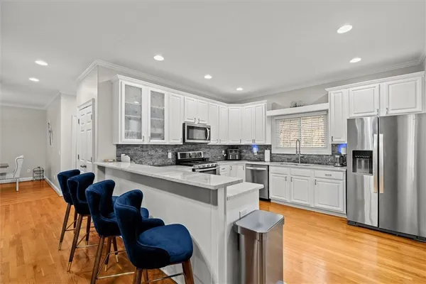 a kitchen with stainless steel appliances granite countertop a stove a sink and a microwave