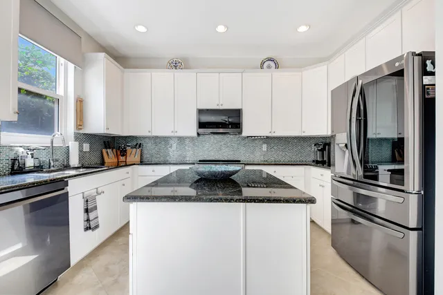 a kitchen with granite countertop a refrigerator stove and microwave