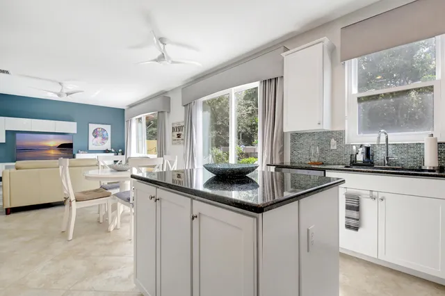 a kitchen with white cabinets and sink