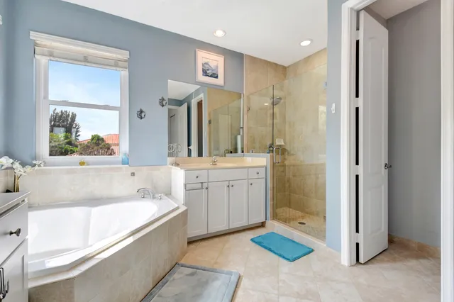 a bathroom with a tub sink shower and mirror