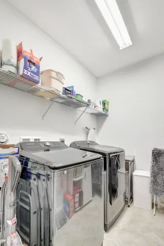 a utility room with stainless steel appliances a sink and cabinets