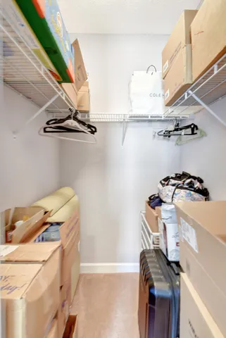 a view of walk in closet with clothes and shoes