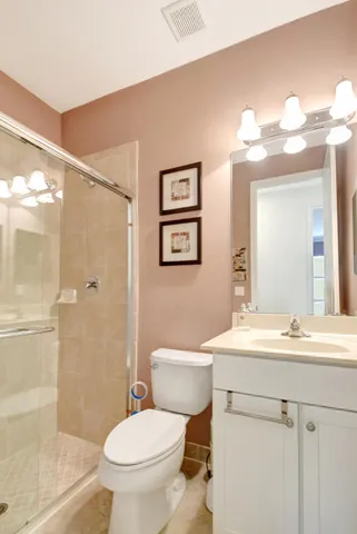 a bathroom with a sink a toilet a mirror and shower