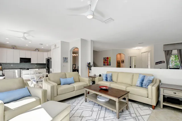 a living room with furniture and a view of kitchen