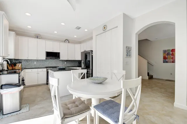 a kitchen with granite countertop white cabinets and stainless steel appliances