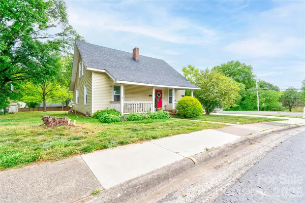 a house with green field in front of it