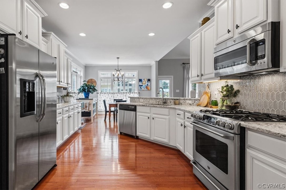 14701 Yarcombe Road Midlothian, VA 23112 - Photo 9 of 44 a kitchen with stainless steel appliances granite countertop a stove top oven a sink dishwasher a refrigerator and white cabinets with wooden floor