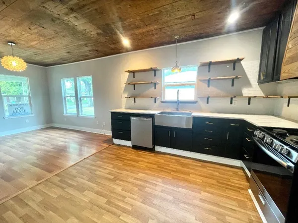 a kitchen with stainless steel appliances granite countertop a sink stove and cabinets