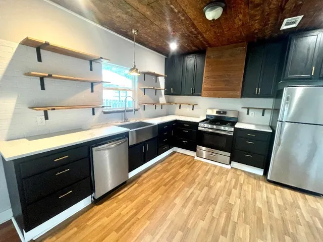 a kitchen with a sink a stove and cabinets