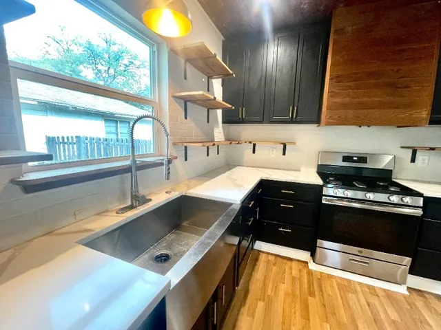 a kitchen with stainless steel appliances sink a stove and a window