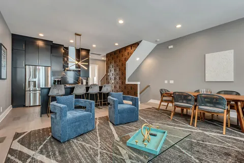 a living room with furniture kitchen view and a large window