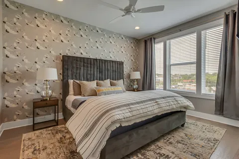 a bed sitting in a spacious bedroom next to a window