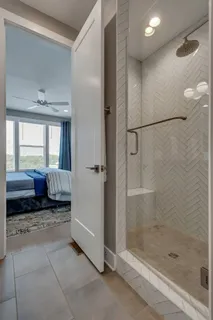 a spacious bathroom with a glass shower door and a window