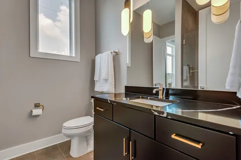 a bathroom with a granite countertop sink and a toilet