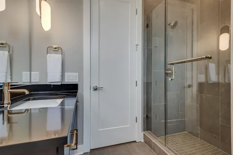 a bathroom with a sink a toilet and shower