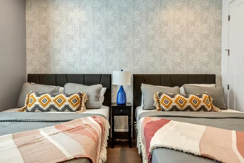 a bed sitting in a bedroom next to a lamp
