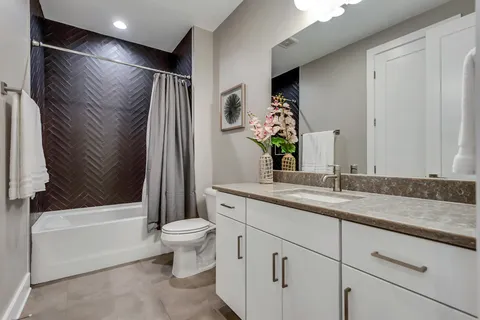 a bathroom with a granite countertop sink toilet and shower