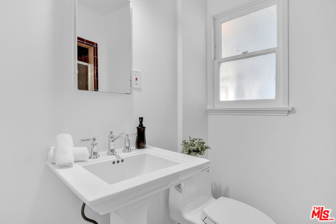 1901 Montecito Drive Glendale, CA 91208 - Photo 32 of 64 a bathroom with a toilet a sink and mirror