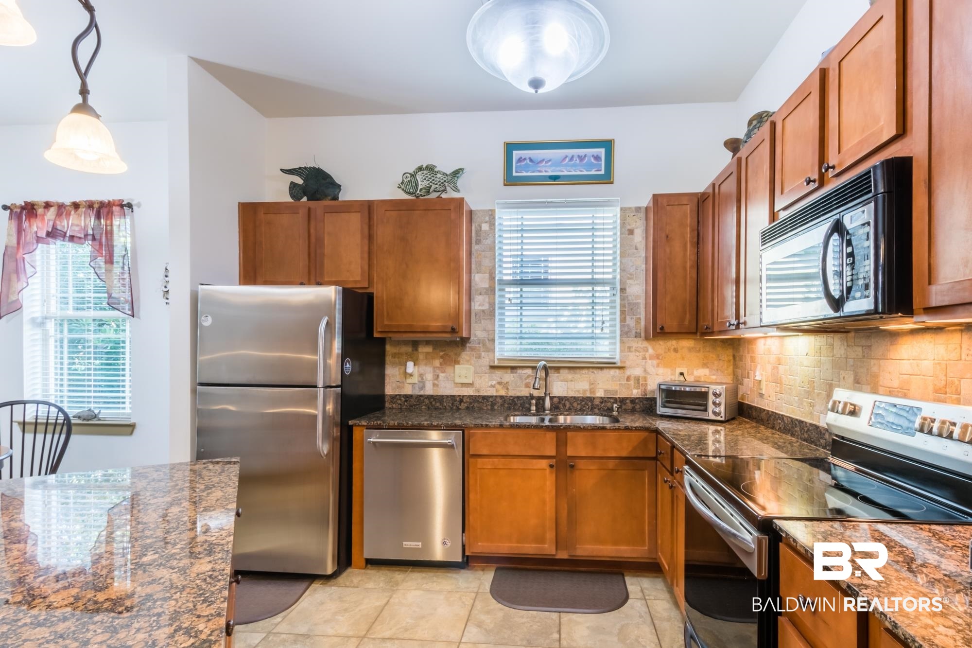 1430 Regency Road, Unit G103 Gulf Shores, AL 36542 - Photo 4 of 29 Kitchen featuring stainless steel appliances, light tile floors, plenty of natural light, and backsplash