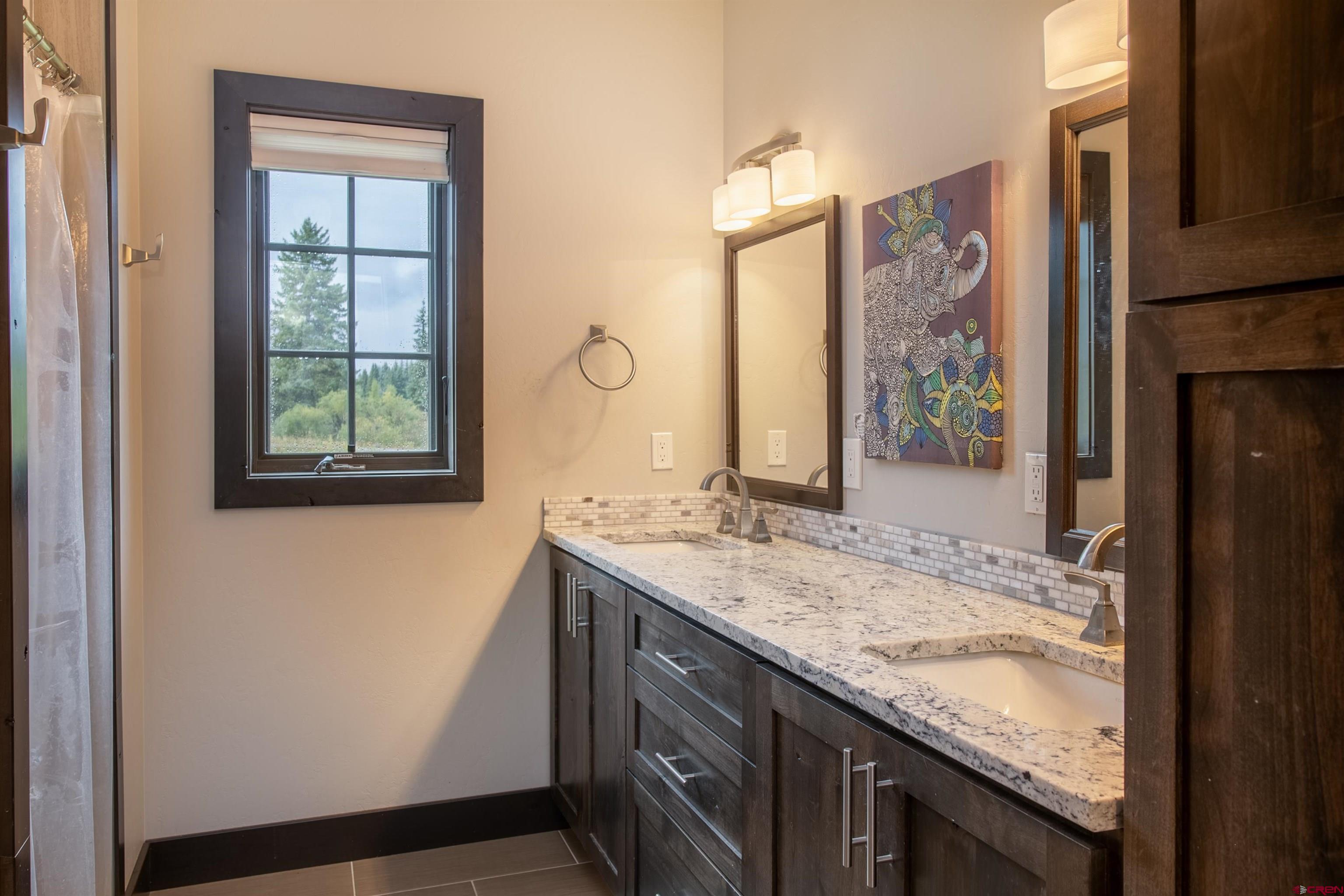23 Jacquelyn Lane Crested Butte, CO 81224 - Photo 21 of 33 a bathroom with a granite countertop sink a mirror and a shower